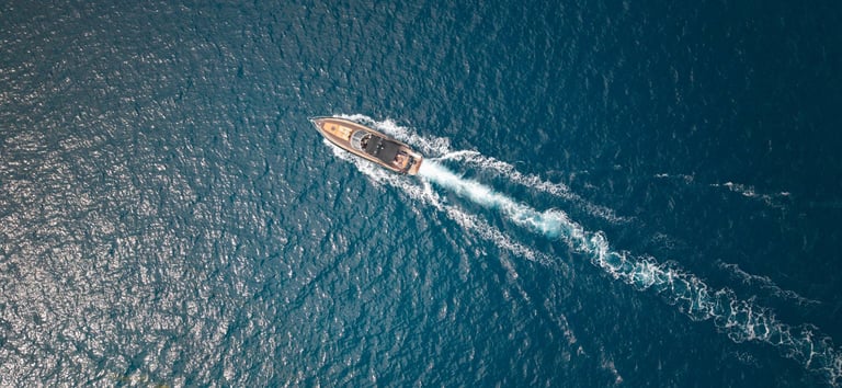 A stunning view of a luxury yacht cutting through the Mediterranean Sea, showcasing the vibrant blue waters