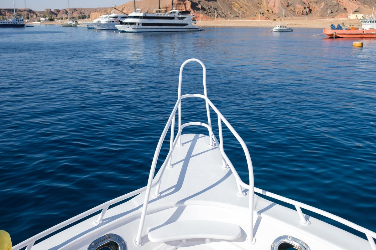 Bow of a clean white yacht with calm blue waters